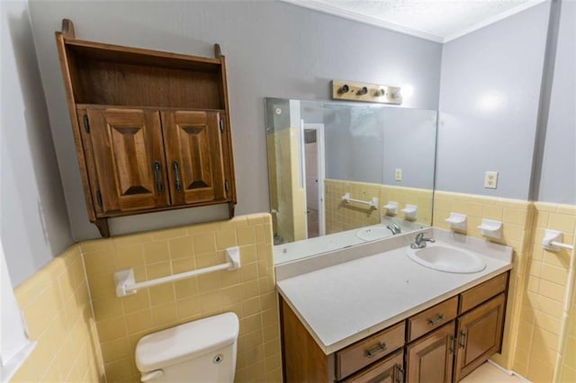 bathroom featuring vanity, toilet, and tile walls