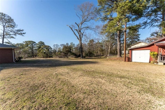 view of yard featuring a garage and an outbuilding