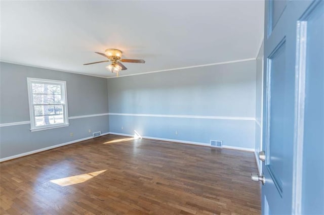 spare room featuring dark wood-type flooring, ornamental molding, and ceiling fan