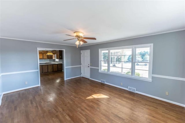 unfurnished living room featuring crown molding, dark wood-type flooring, and ceiling fan