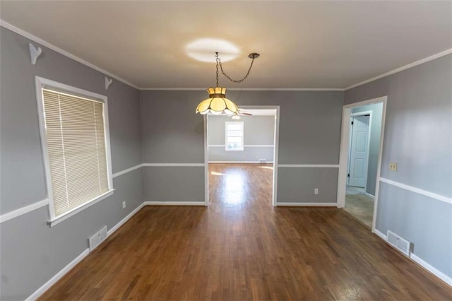 spare room featuring dark wood-type flooring and ornamental molding