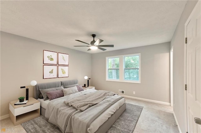 bedroom with ceiling fan and light carpet