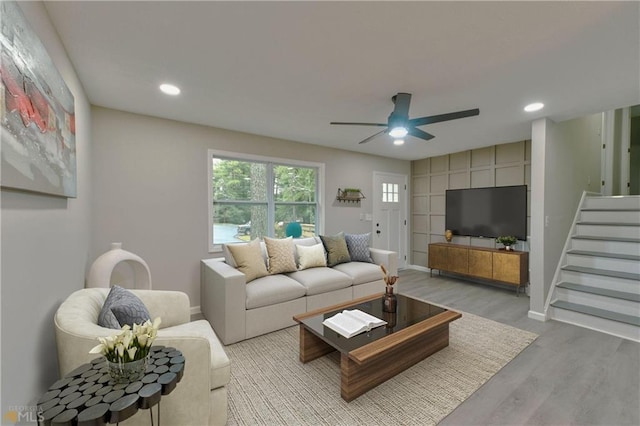 living room featuring light hardwood / wood-style floors and ceiling fan