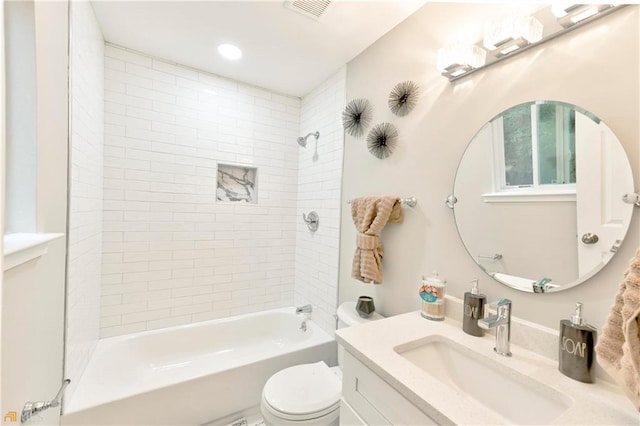 full bathroom featuring toilet, vanity, and tiled shower / bath