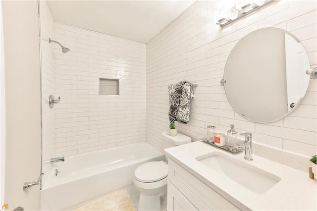 full bathroom with tile walls, toilet, tiled shower / bath combo, and vanity