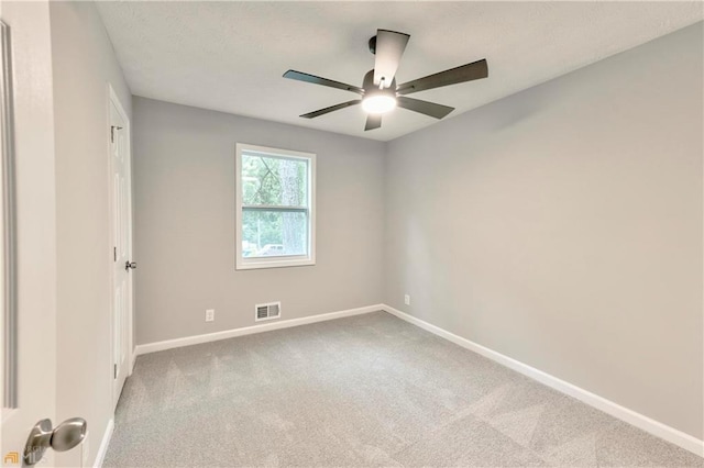 empty room with ceiling fan and light carpet