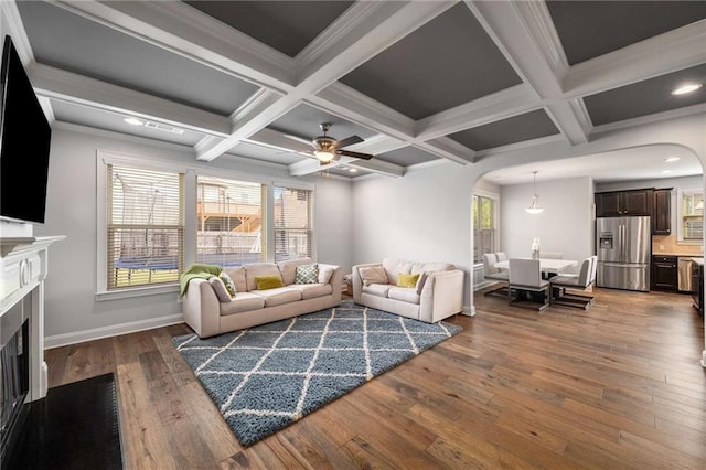 1520 Gallant Fox Ln, Suwanee, GA 30024 - living area featuring arched walkways, wood finished floors, a fireplace with flush hearth, baseboards, and coffered ceiling