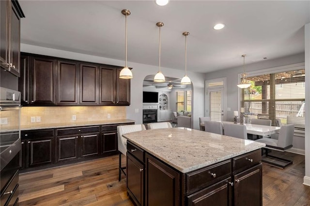 1520 Gallant Fox Ln, Suwanee, GA 30024 - kitchen featuring a ceiling fan, dark wood finished floors, tasteful backsplash, light stone countertops, and recessed lighting