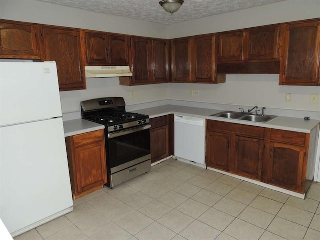 kitchen featuring a textured ceiling, white appliances, and sink