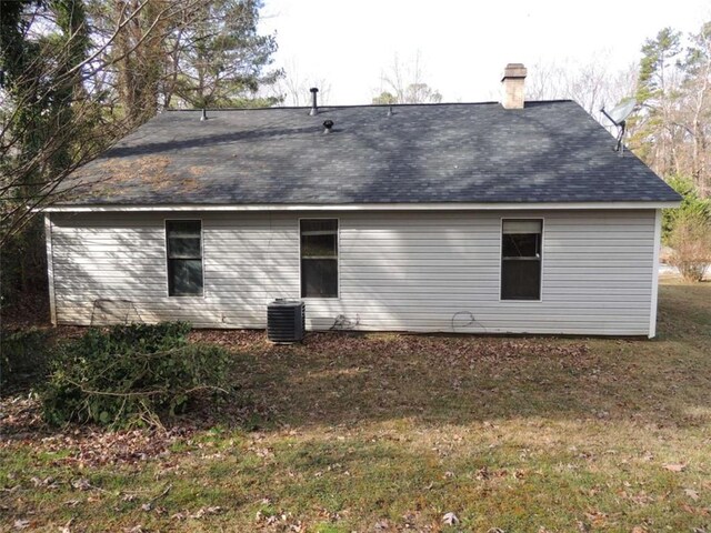 rear view of house featuring a yard and central air condition unit