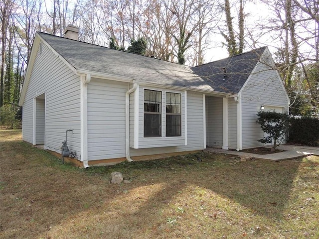 view of side of property featuring a garage and a yard