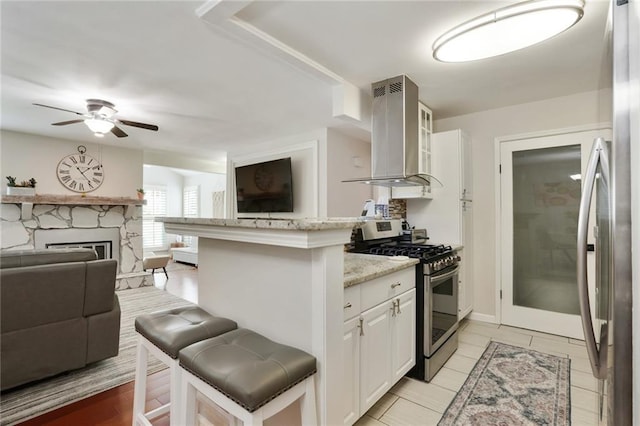 3210 Lake Pointe Cir, Roswell, GA 30075 - kitchen featuring appliances with stainless steel finishes, exhaust hood, a kitchen bar, ceiling fan, and open floor plan