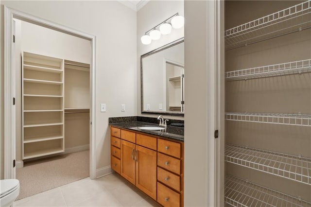 3621 Vinings Slope SE Unit 3510, Atlanta, GA 30339 - bathroom featuring vanity, tile patterned flooring, a spacious closet, toilet, and crown molding