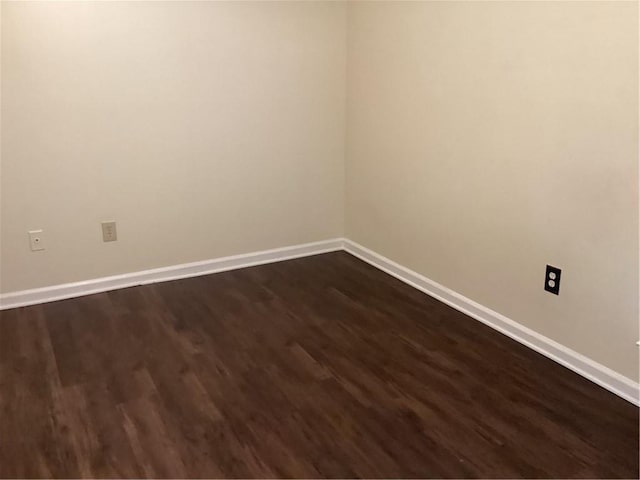 empty room with dark hardwood / wood-style flooring