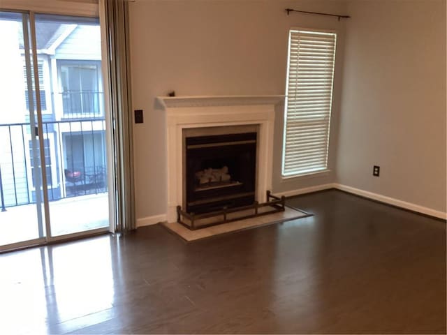 unfurnished living room with dark wood-type flooring