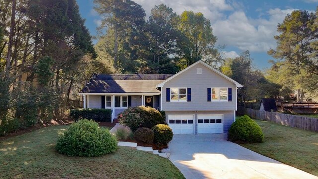 tri-level home featuring a front lawn and a garage