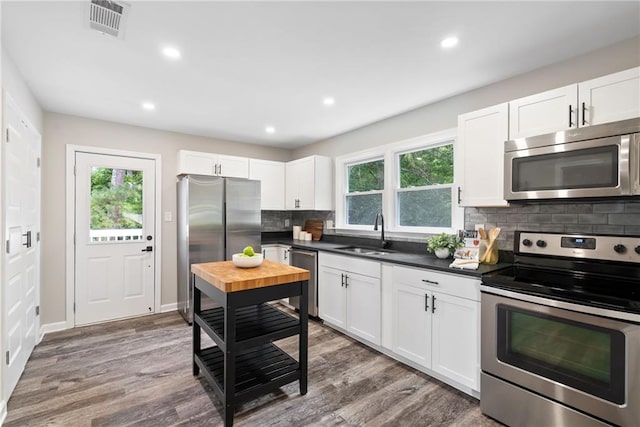 96 Senoia Rd, Fairburn, GA 30213 - kitchen featuring appliances with stainless steel finishes, backsplash, wood finished floors, white cabinetry, and recessed lighting