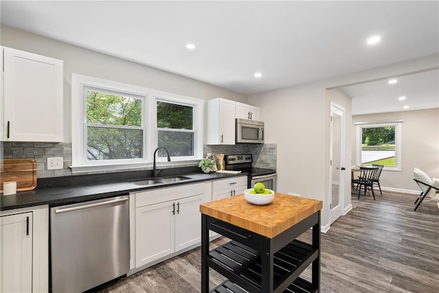 96 Senoia Rd, Fairburn, GA 30213 - kitchen with appliances with stainless steel finishes, dark countertops, backsplash, wood finished floors, and white cabinetry