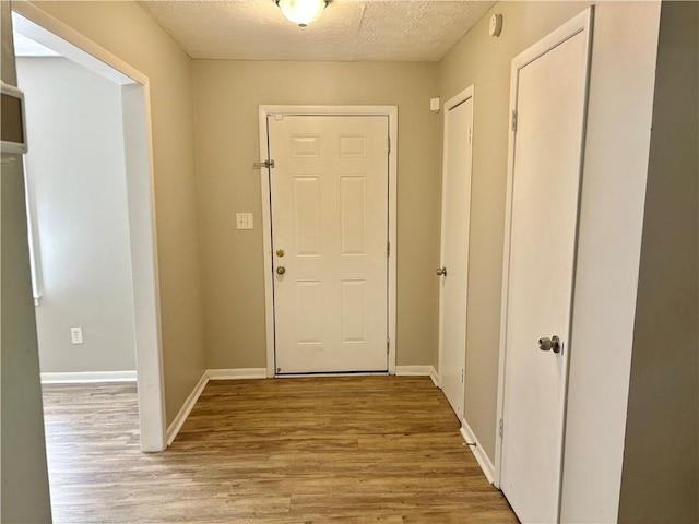 entryway with light hardwood / wood-style flooring and a textured ceiling