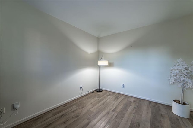 empty room featuring baseboards and wood finished floors