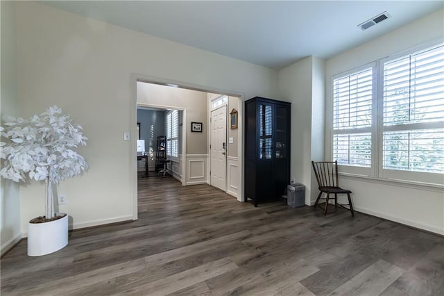 entrance foyer featuring baseboards, visible vents, and wood finished floors