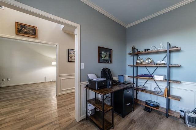 office space featuring a wainscoted wall, crown molding, a decorative wall, and wood finished floors