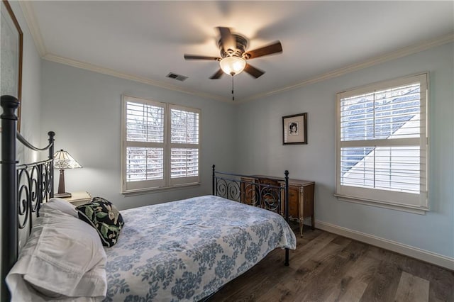 bedroom with ornamental molding, wood finished floors, visible vents, and baseboards