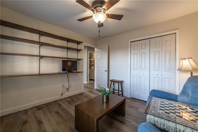 living area featuring ceiling fan, baseboards, and wood finished floors