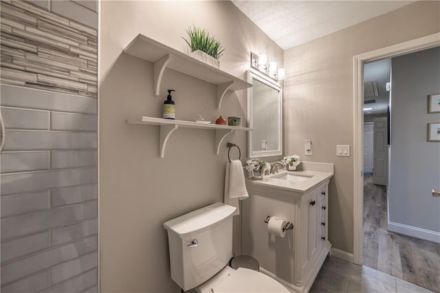 bathroom featuring baseboards, vanity, and toilet