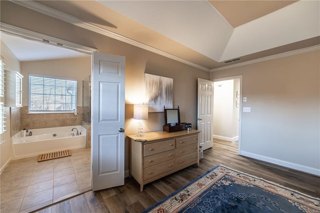 bedroom with visible vents, vaulted ceiling, baseboards, and wood finished floors