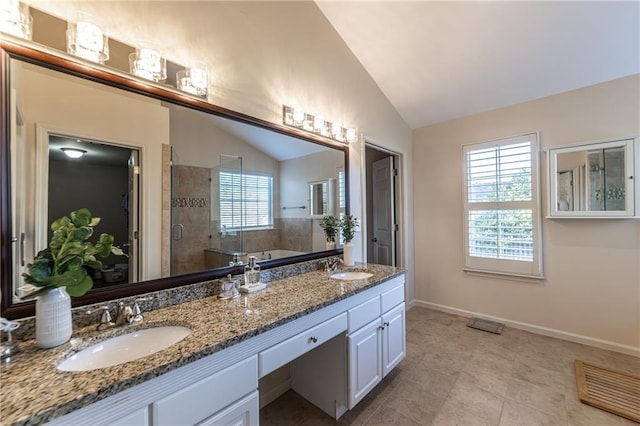 bathroom featuring lofted ceiling, double vanity, a stall shower, and a sink