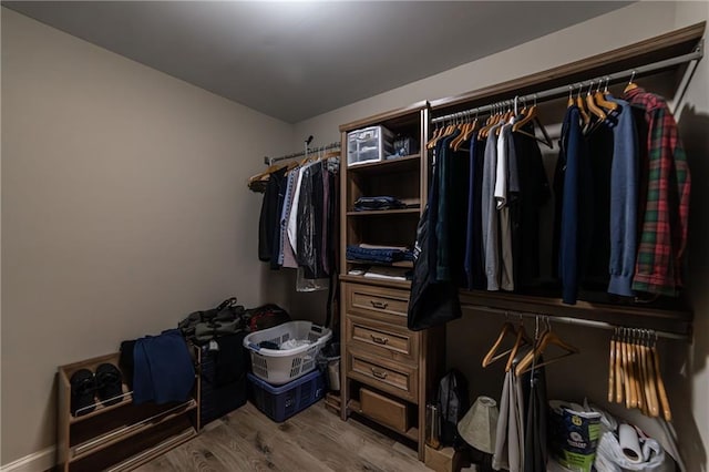 walk in closet with wood finished floors