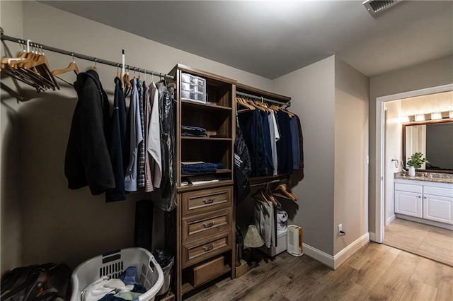 walk in closet with light wood finished floors and visible vents