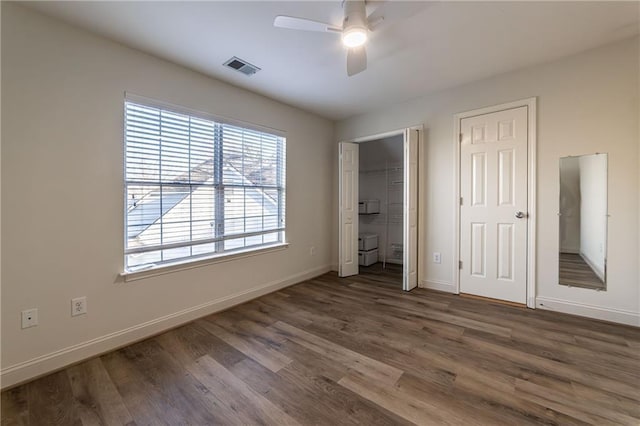 unfurnished bedroom with visible vents, baseboards, and wood finished floors