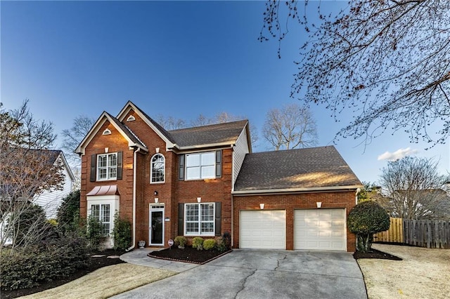 colonial-style house with concrete driveway, brick siding, an attached garage, and fence