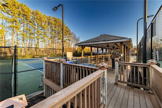 deck with a tennis court and fence