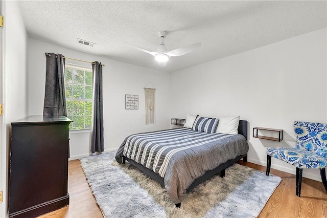 1357 Railroad Ave, Sugar Hill, GA 30518 - bedroom with light wood-style flooring, a textured ceiling, baseboards, and ceiling fan