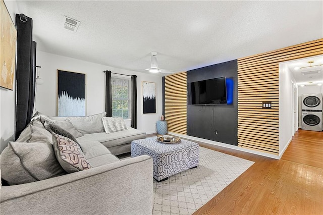 1357 Railroad Ave, Sugar Hill, GA 30518 - living area featuring stacked washer / drying machine, wood finished floors, a textured ceiling, a ceiling fan, and baseboards