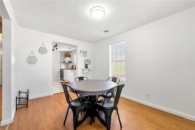 1357 Railroad Ave, Sugar Hill, GA 30518 - dining area featuring a textured ceiling, light wood finished floors, and baseboards