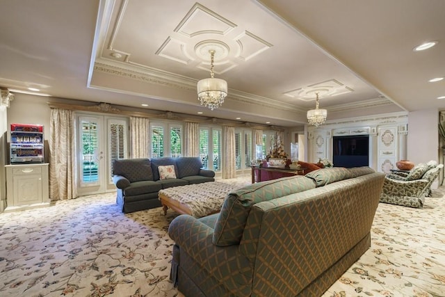 carpeted living room with a notable chandelier, ornamental molding, and a tray ceiling