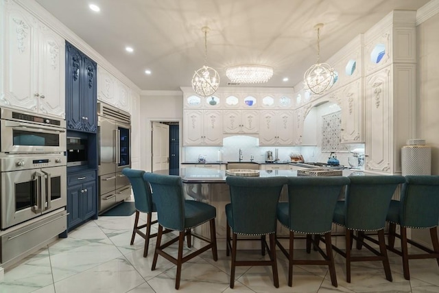 kitchen with blue cabinets, a kitchen breakfast bar, a chandelier, and stainless steel appliances