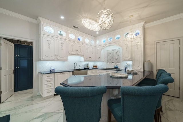 kitchen featuring a chandelier, white cabinetry, light tile floors, pendant lighting, and sink