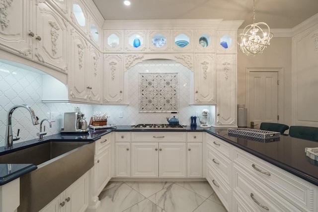 kitchen with white cabinets, decorative light fixtures, a chandelier, and tasteful backsplash