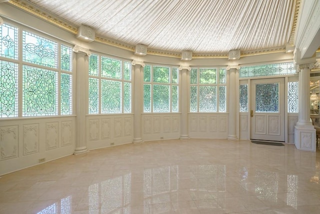 unfurnished sunroom featuring ornate columns and plenty of natural light