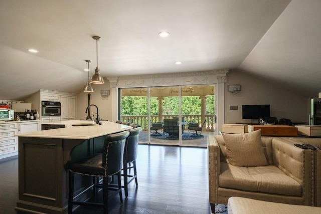 kitchen with white cabinets, sink, a breakfast bar, oven, and dark hardwood / wood-style floors