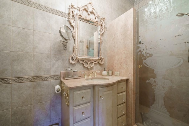 bathroom with a shower, vanity with extensive cabinet space, and tile walls