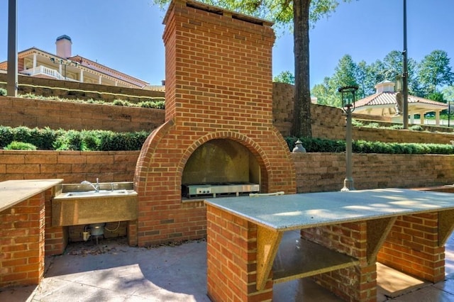 view of patio featuring exterior kitchen and a fireplace