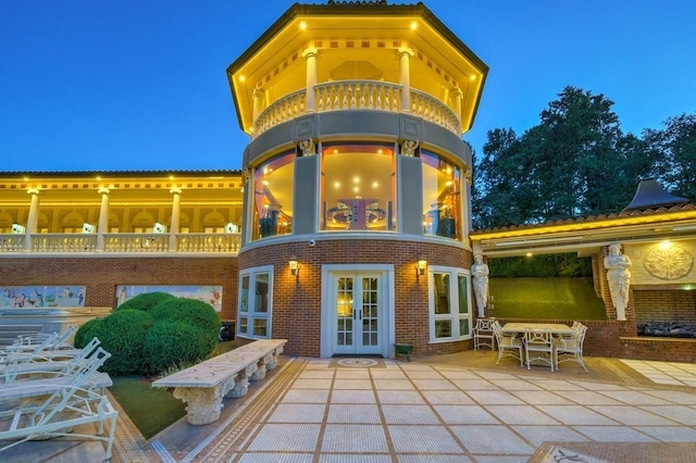 back house at night with a patio area and french doors