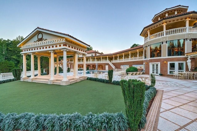 rear view of property featuring a pool and a patio