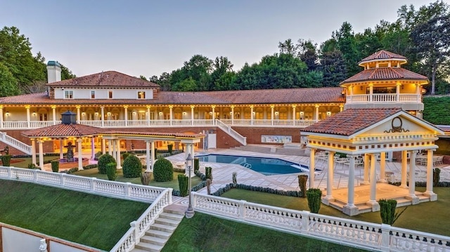 back of property featuring a patio, a lawn, a gazebo, and a fenced in pool